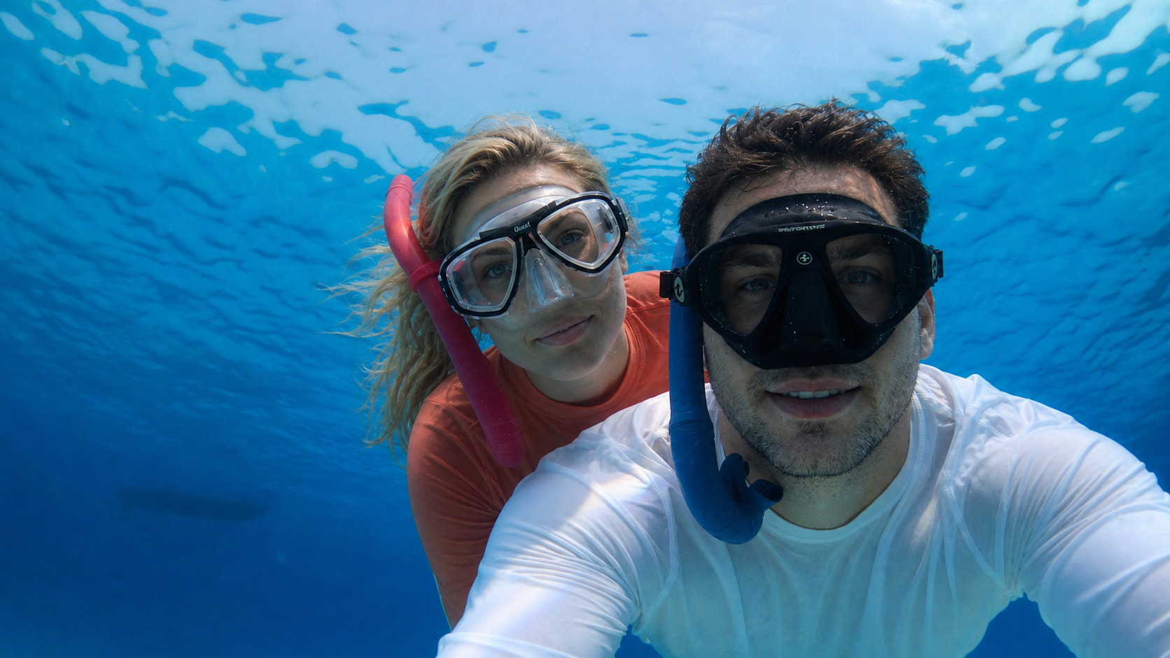 A young couple snorkelling together in clear blue water